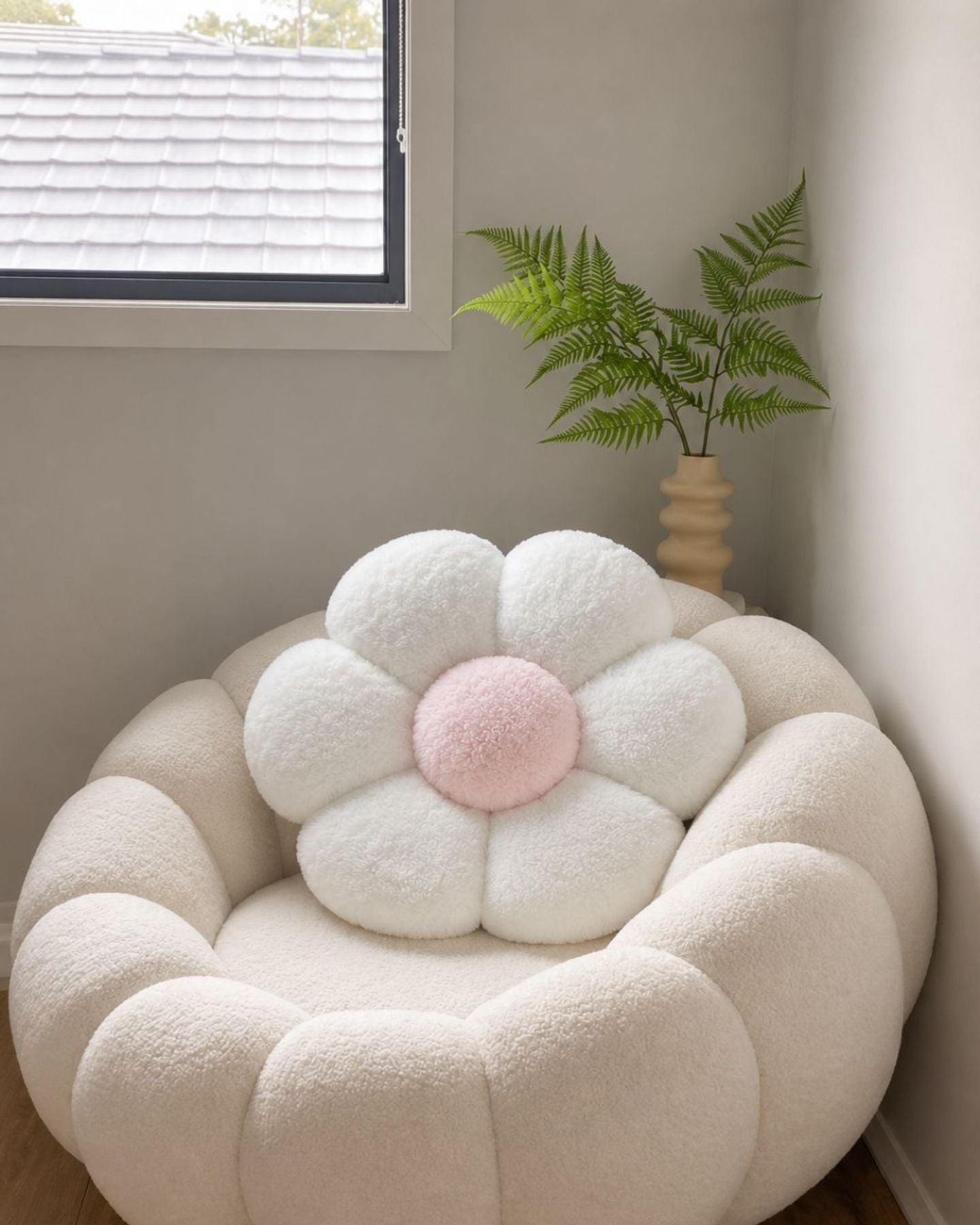 White and pink flower cushion on a bouclé armchair