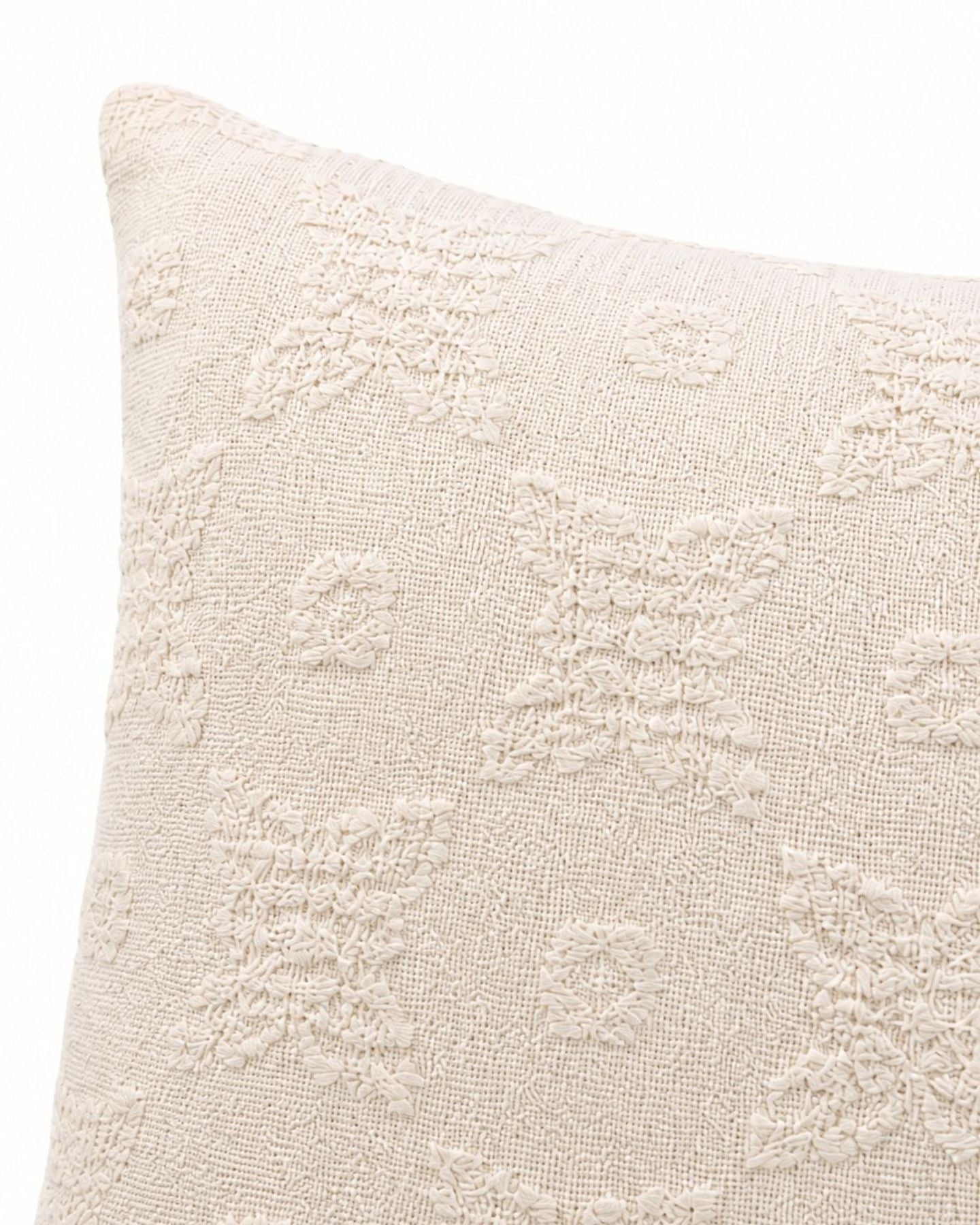 Close-up of the cream cushion's raised floral texture